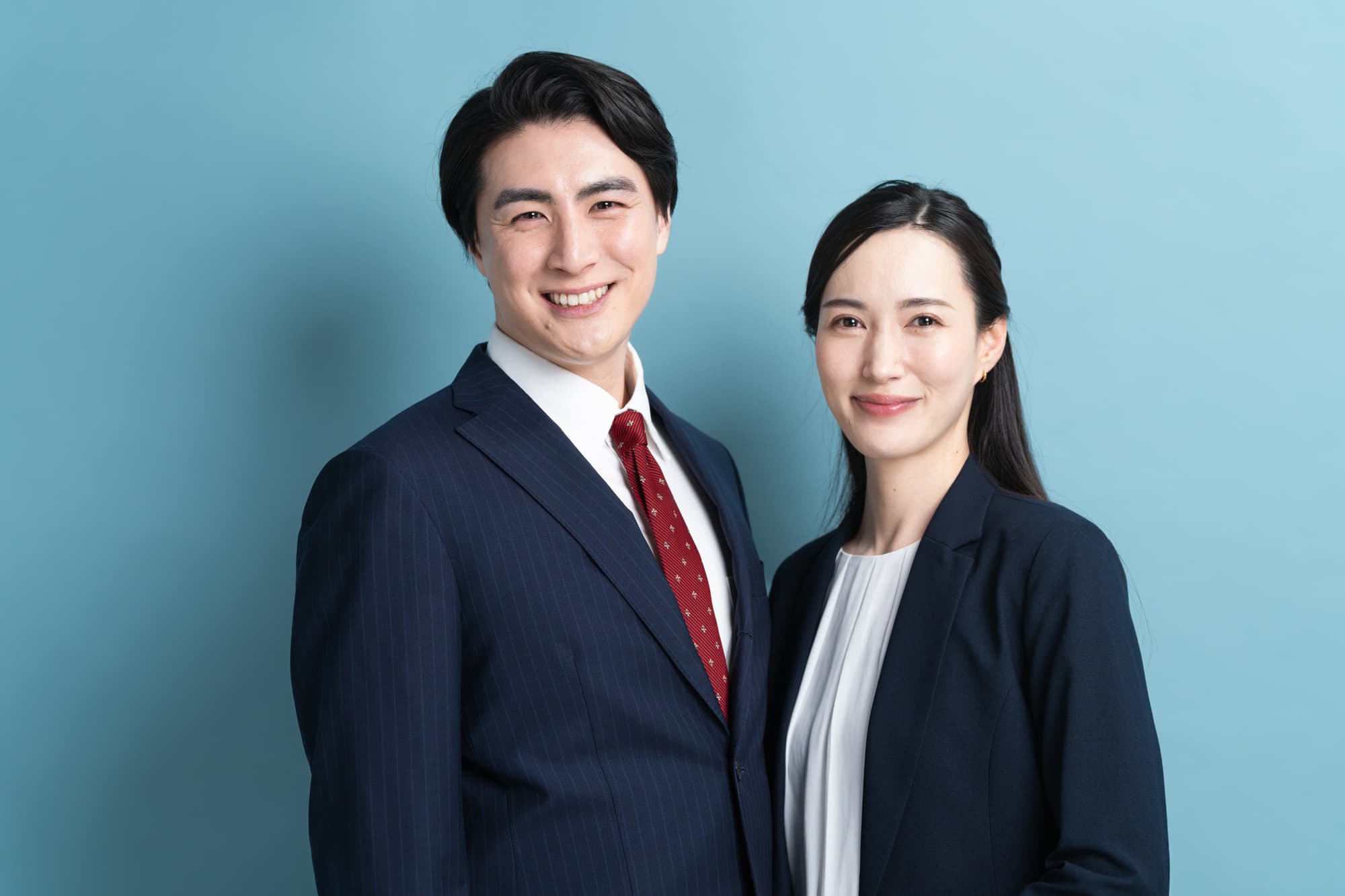 スーツを着て笑顔を浮かべる男女のポートレート