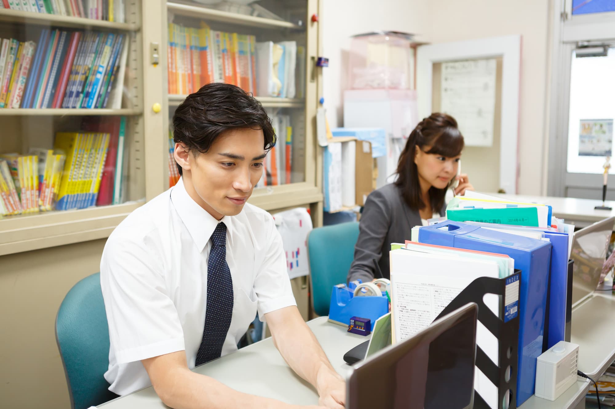 職員室で仕事をする2人の教師

