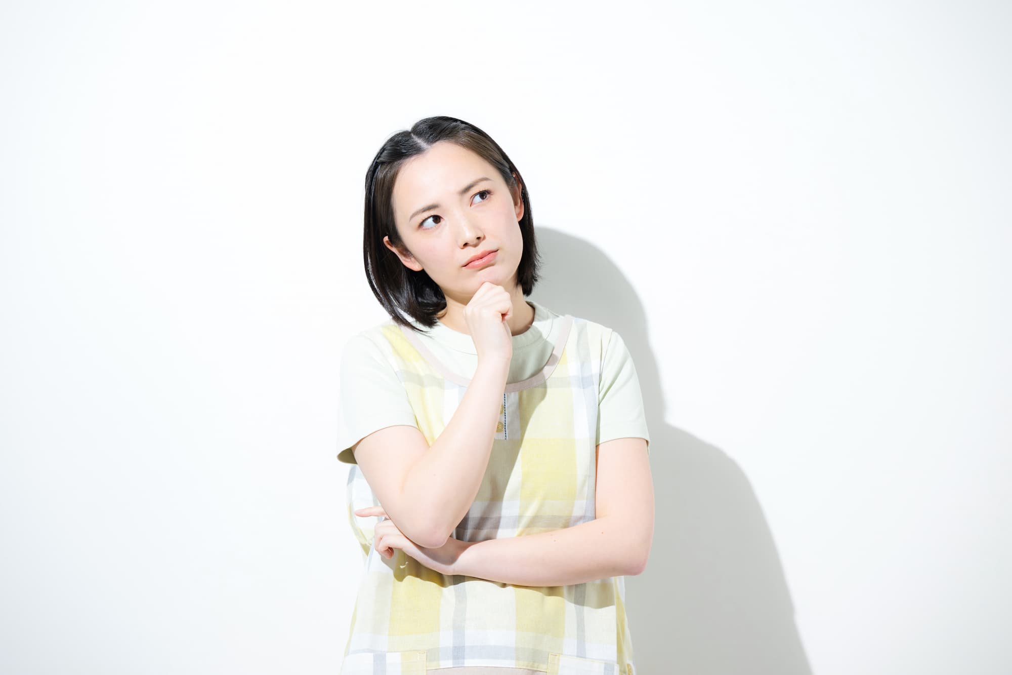 腕を組み悩んだ表情をしている保育士