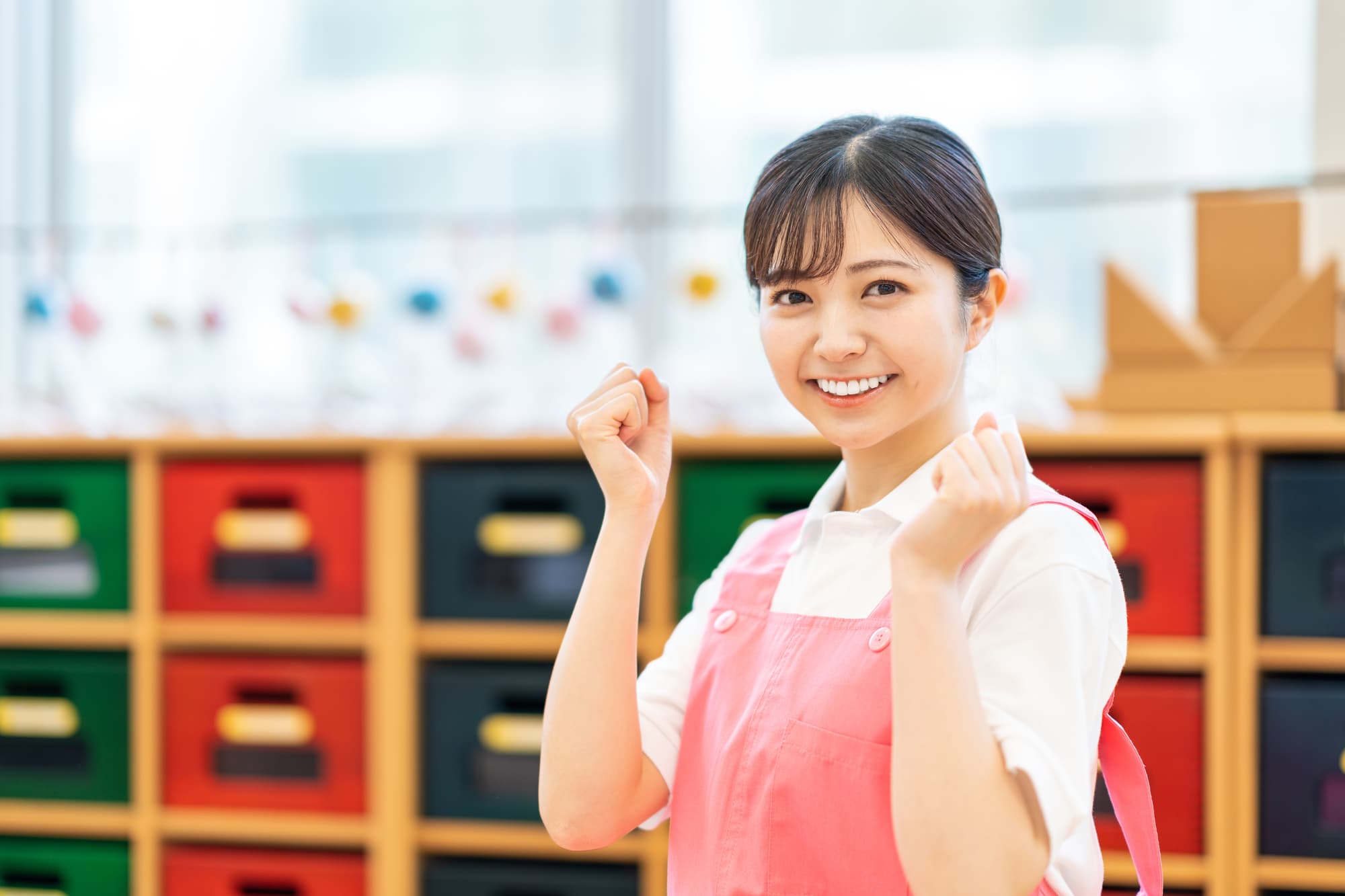 笑顔でガッツポーズをしている保育士