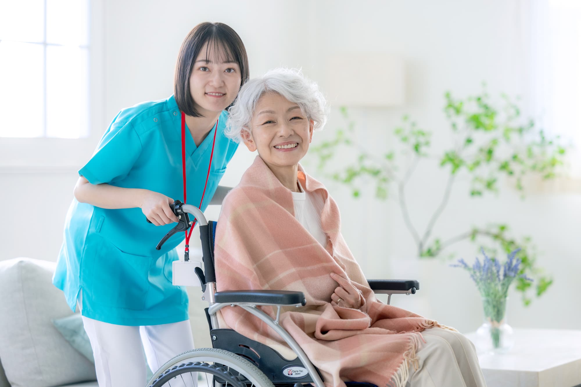 車椅子のシニア女性と介護士