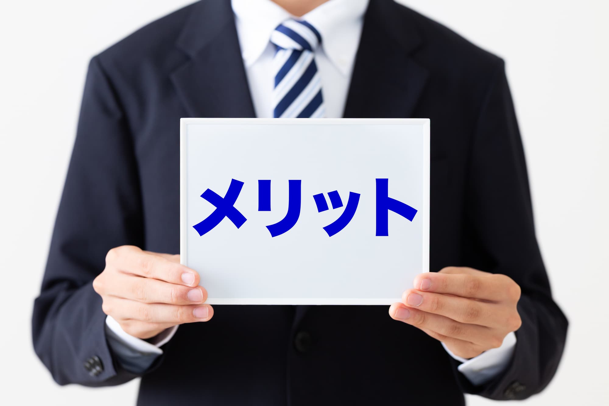 青地でメリットと書かれているボードを持っている人
