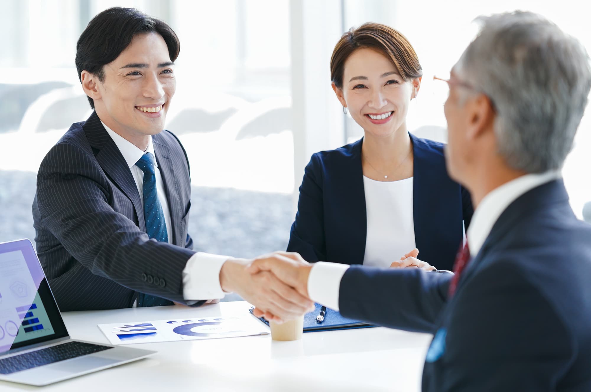 オフィスで握手しているビジネスパーソン
